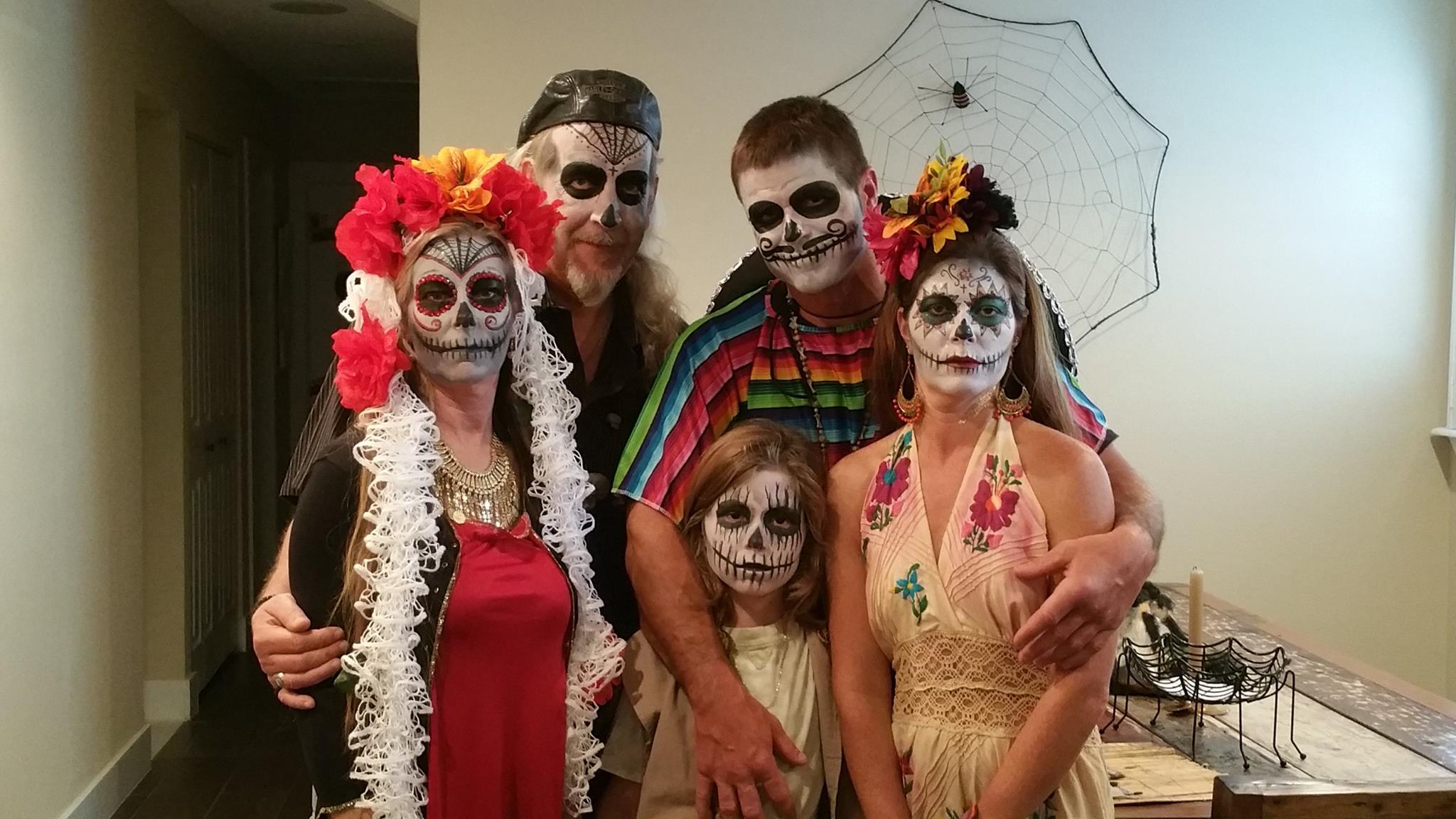 A group of people with faces painted for halloween.