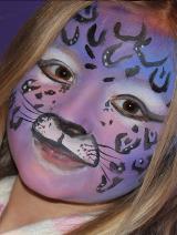 A girl with purple and black leopard print face paint.