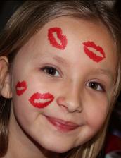 A little girl with lipstick on her face.
