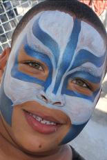 A boy with blue and white face paint.