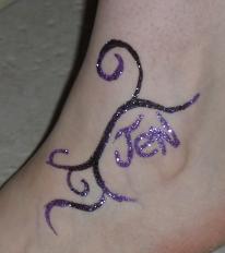 A purple and black tattoo on the ankle of someone.