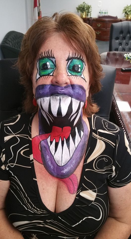 A woman with her face painted like a monster.