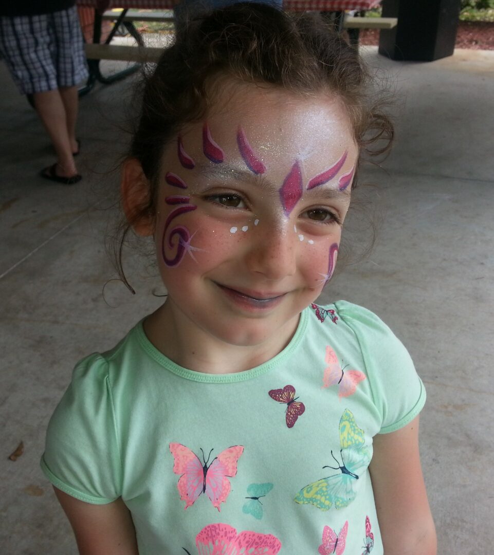A little girl with face paint on her face.
