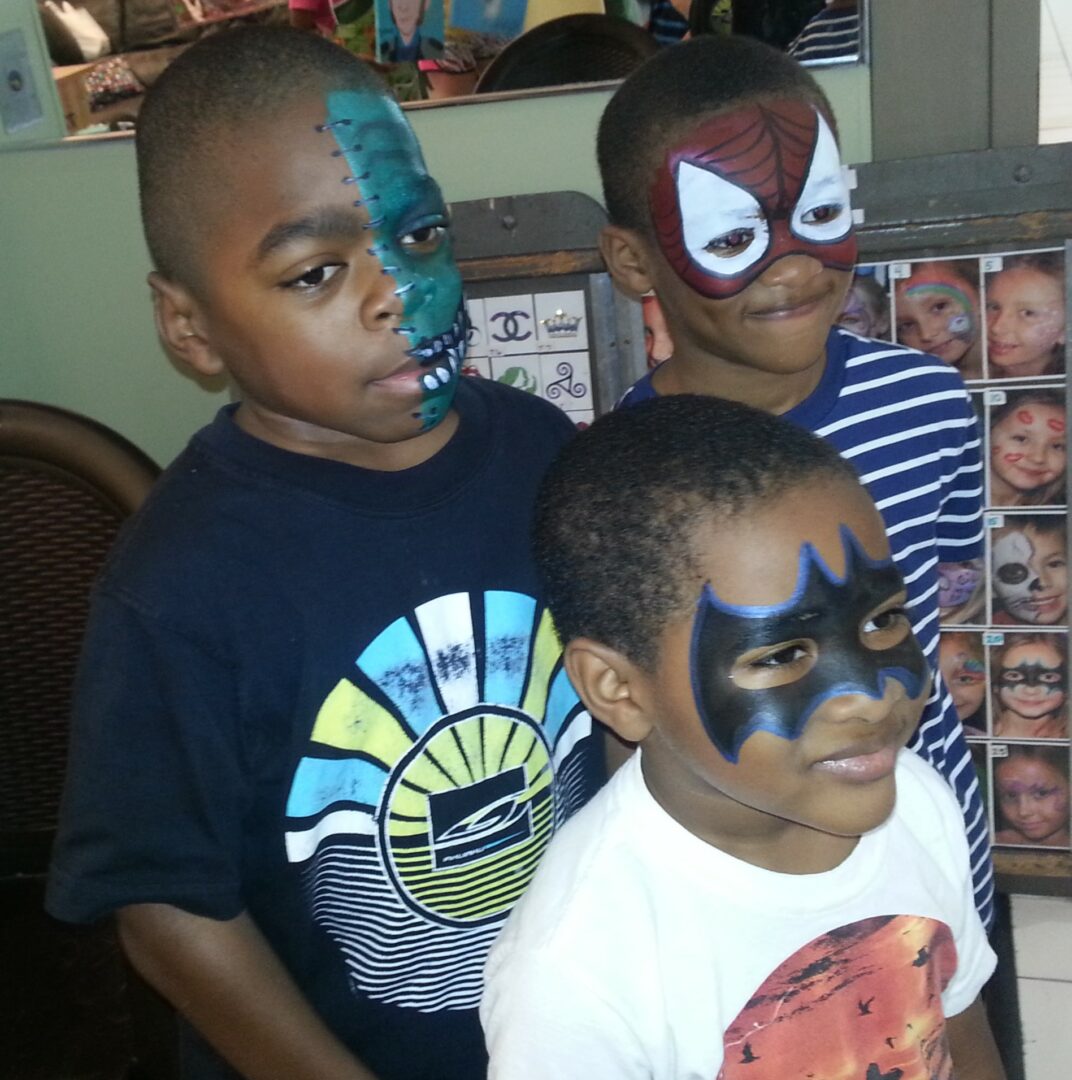 Three boys with face paint on their faces.
