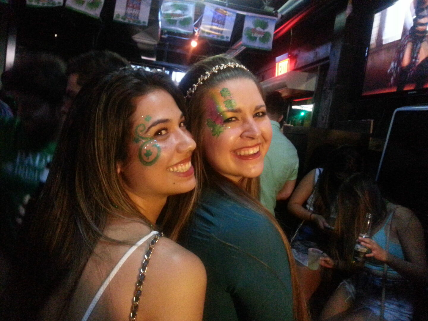 Two women with face paint pose for a picture.