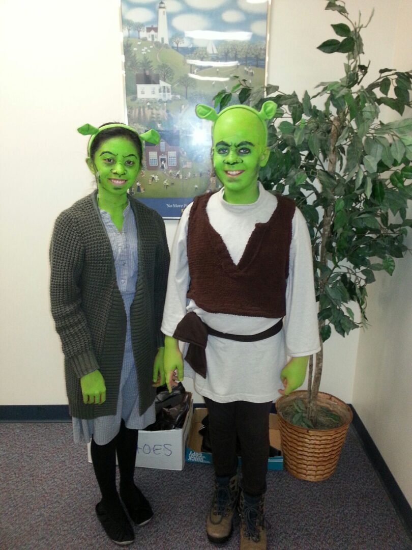 Two people dressed as shrek and a plant
