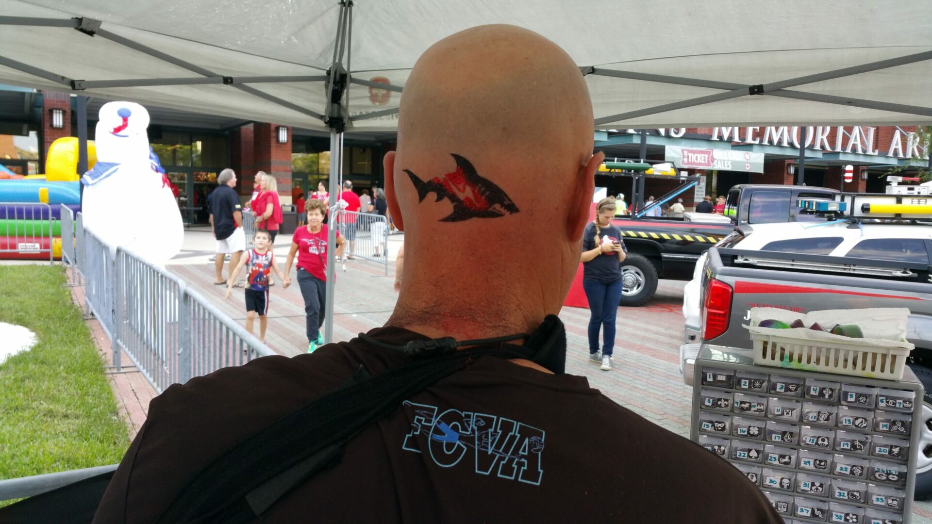 A man with a shark tattoo on his head.