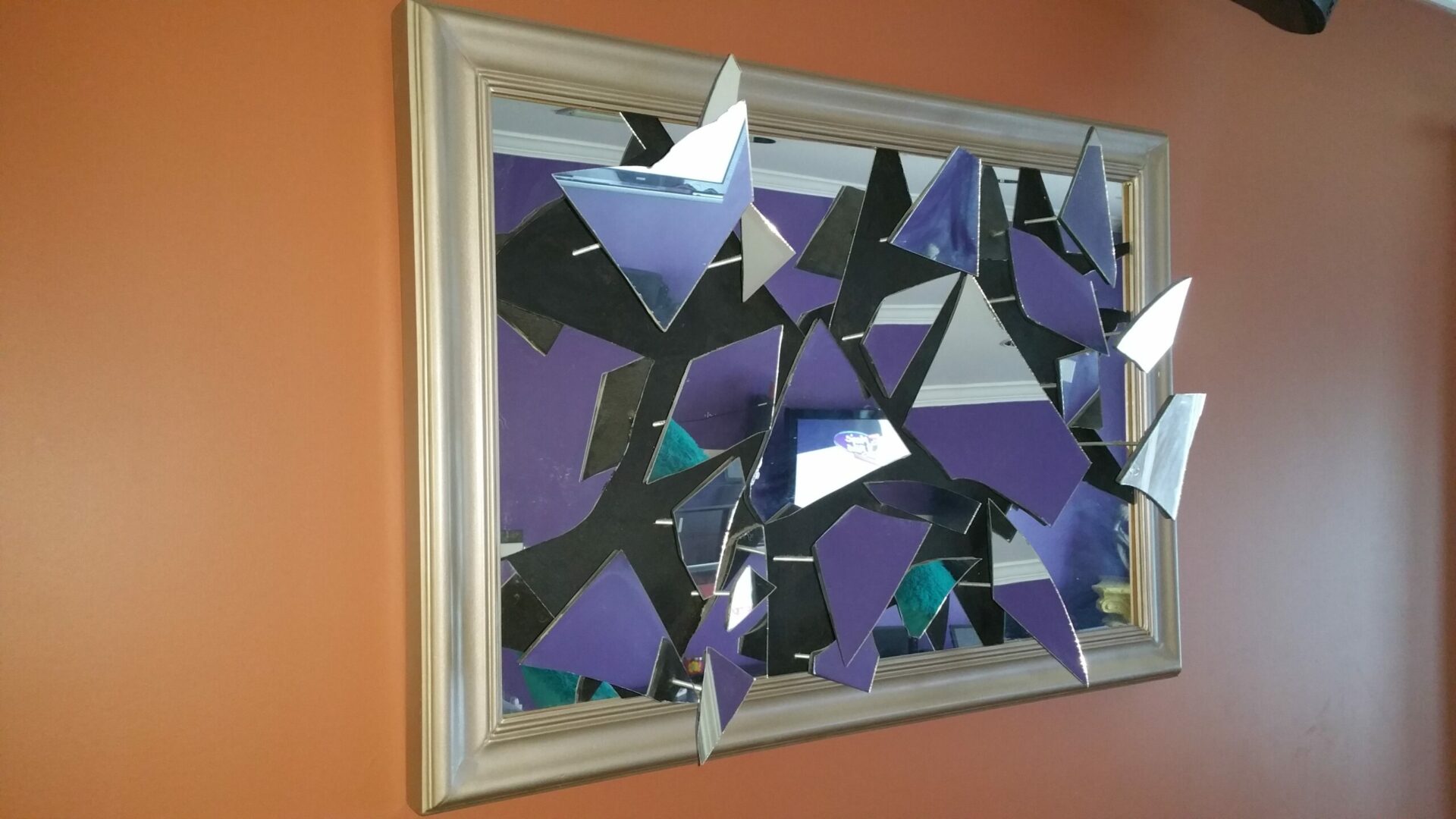 A mirror with purple and black broken mirrors on it.