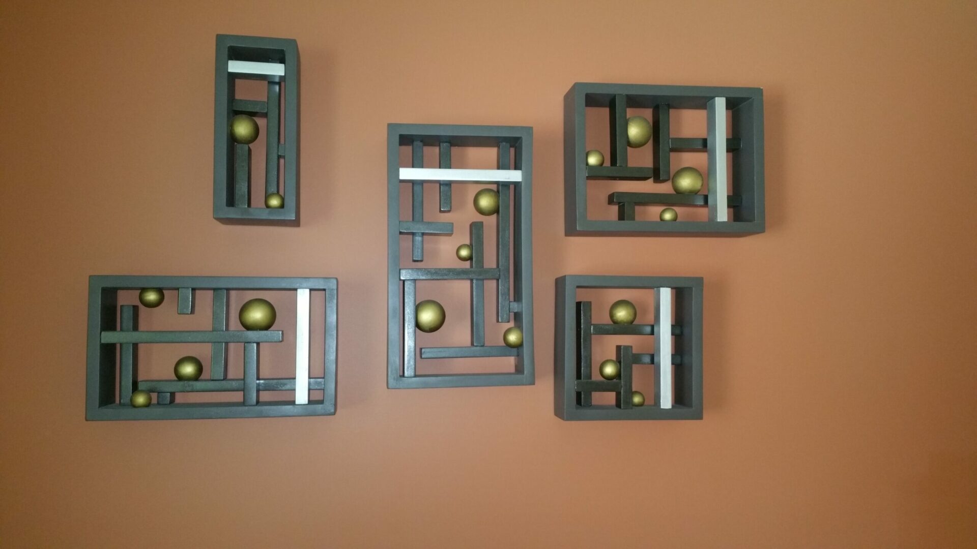 A wall with some wooden blocks and balls on it