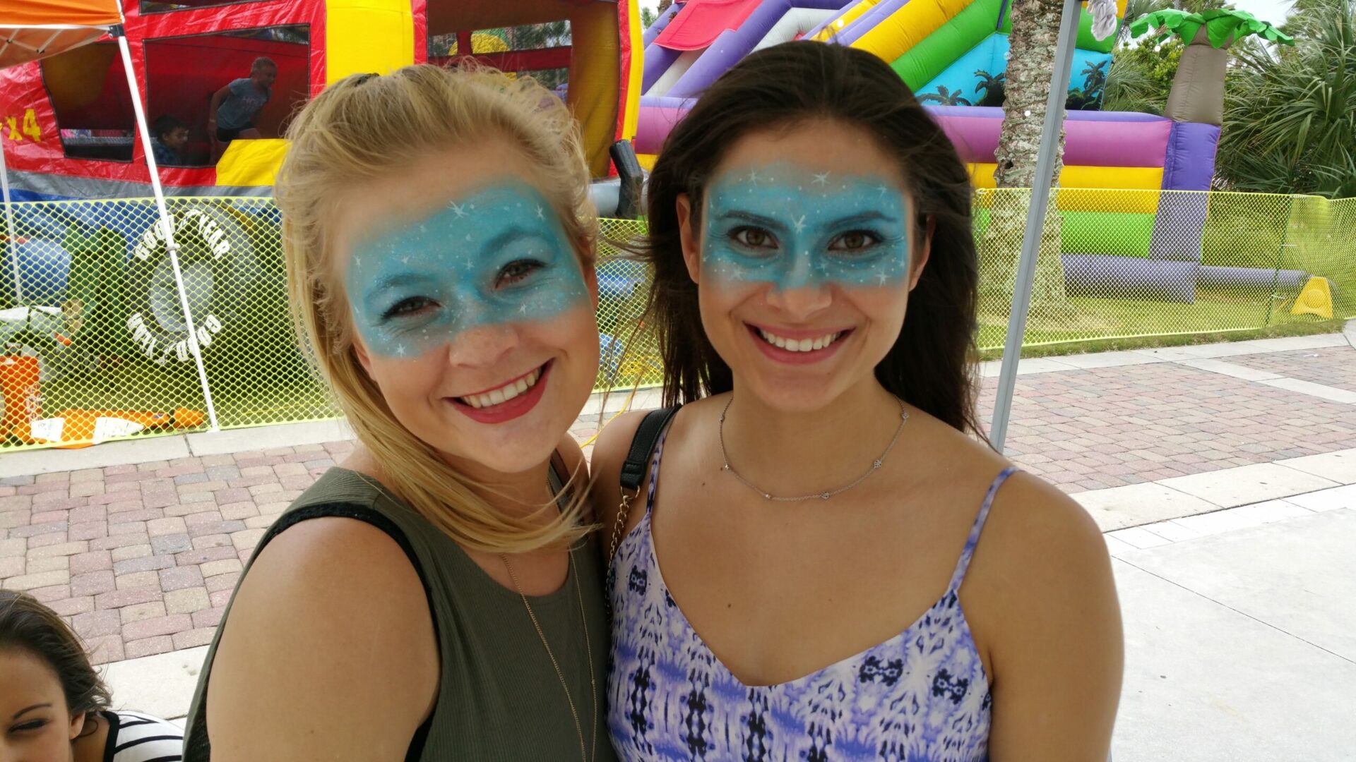 Two women with blue face paint posing for a picture.