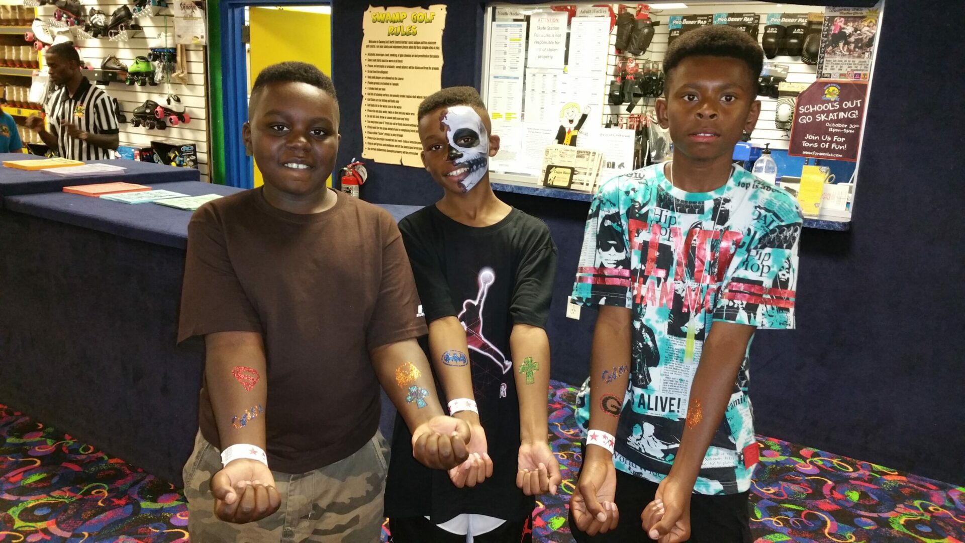 Three young men with their faces painted and holding hands.