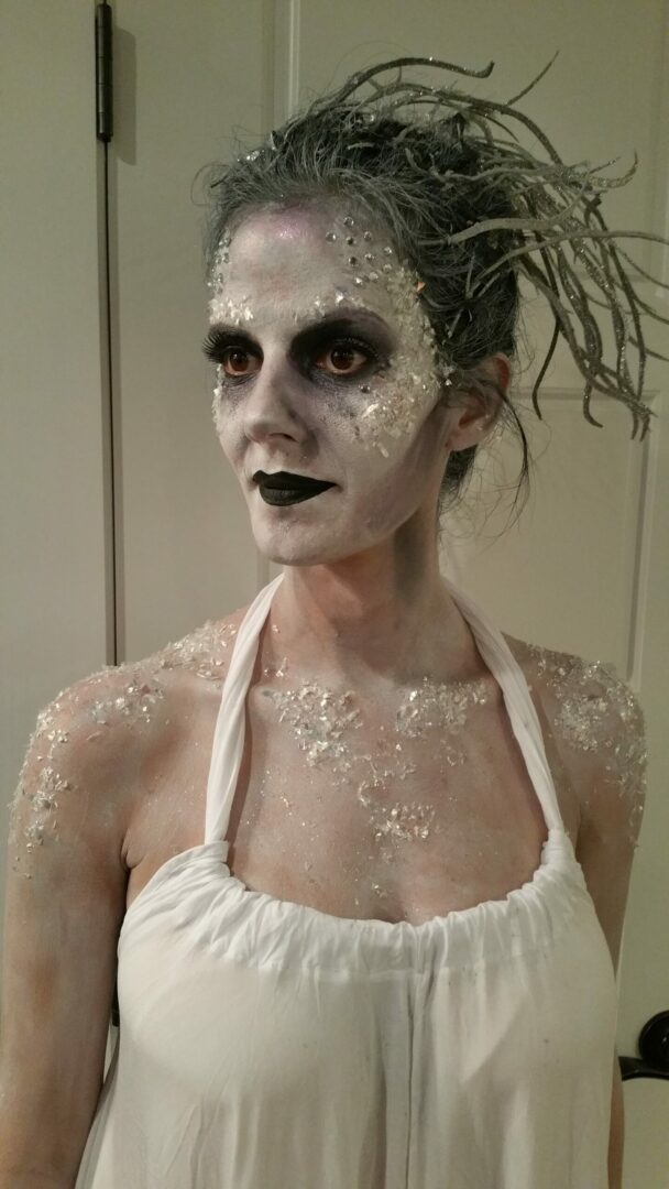 A woman with white makeup on her face.