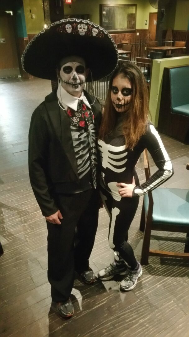 A man and woman dressed up as skeletons.