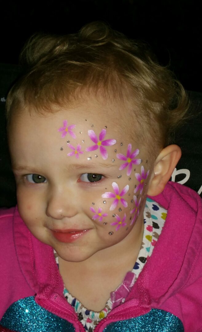 A little girl with flowers painted on her face.
