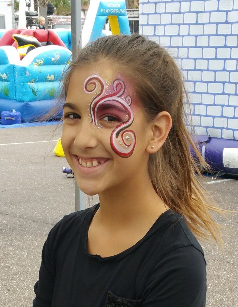 A girl with a face paint on her cheek.