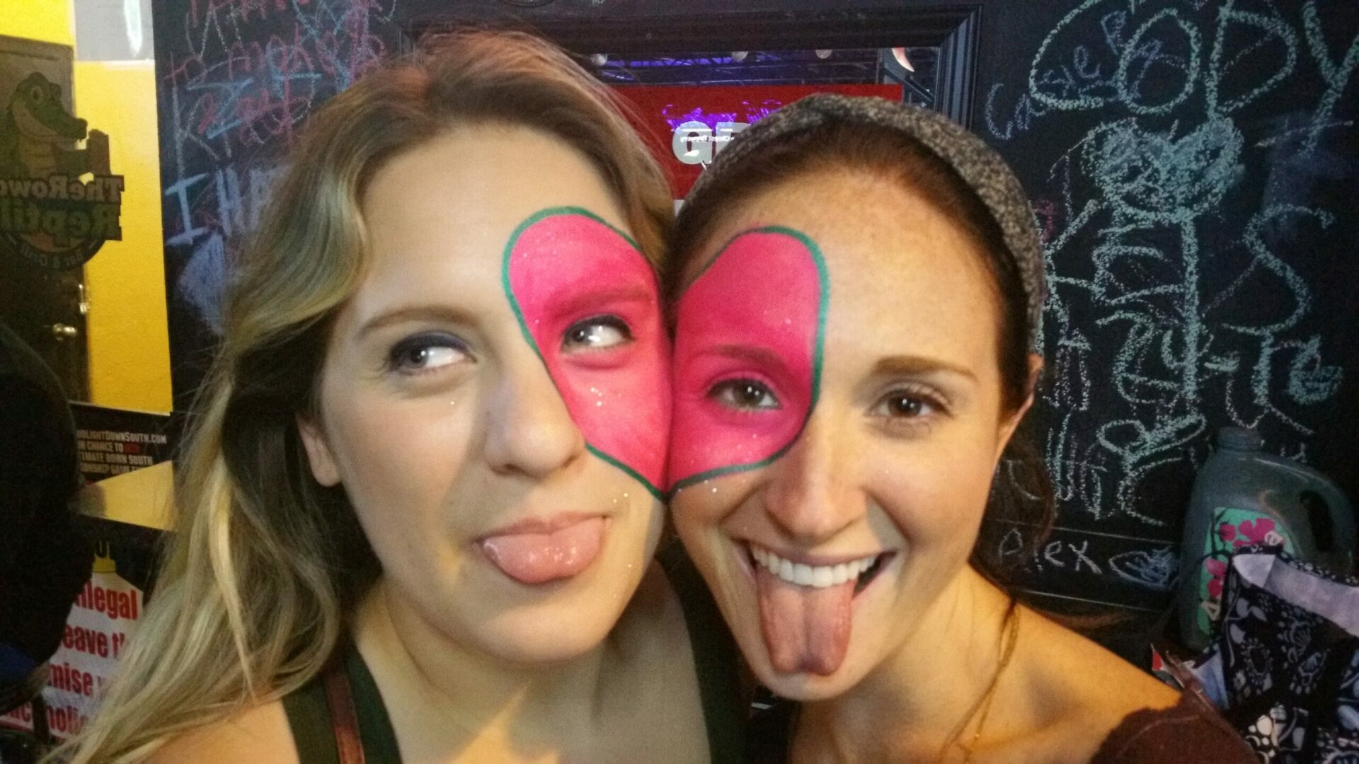 Two women with painted faces on their heads.