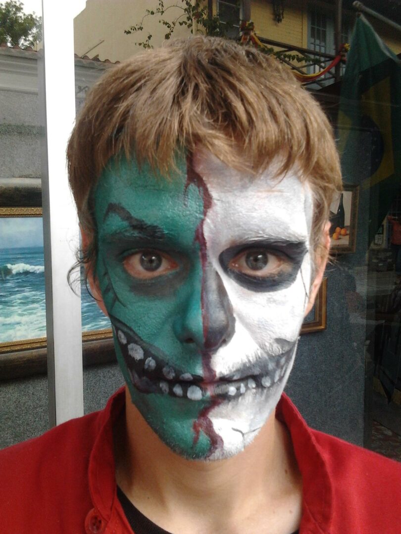 A man with his face painted like a skeleton.