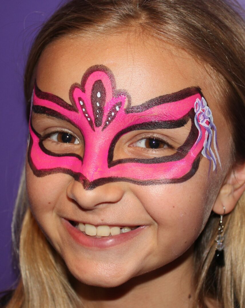 A girl with pink and brown face paint.