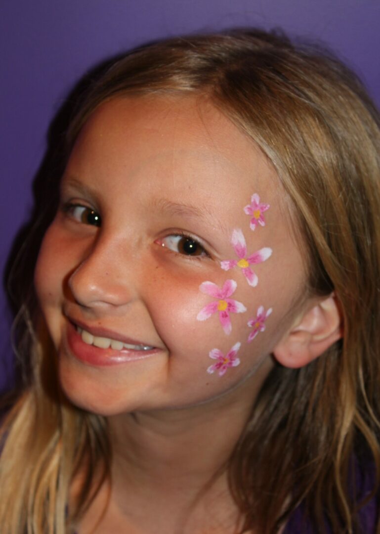 A girl with pink flowers painted on her face.