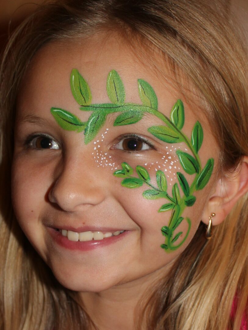 A girl with green leaves painted on her face.