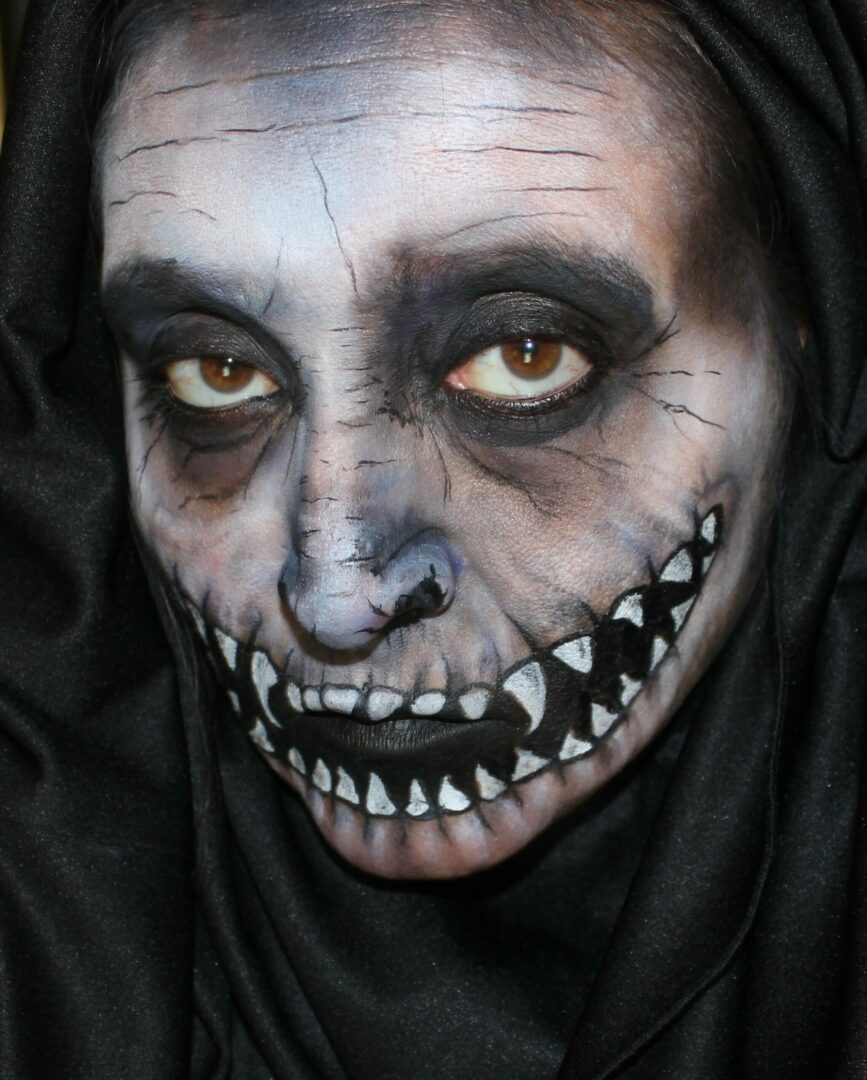 A person with white and black makeup on their face.