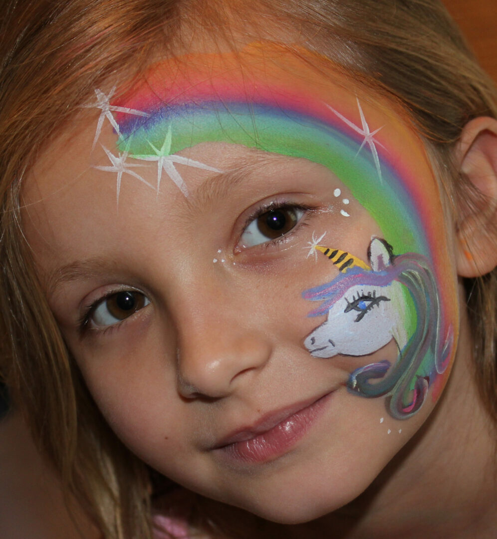 A girl with her face painted like a unicorn.