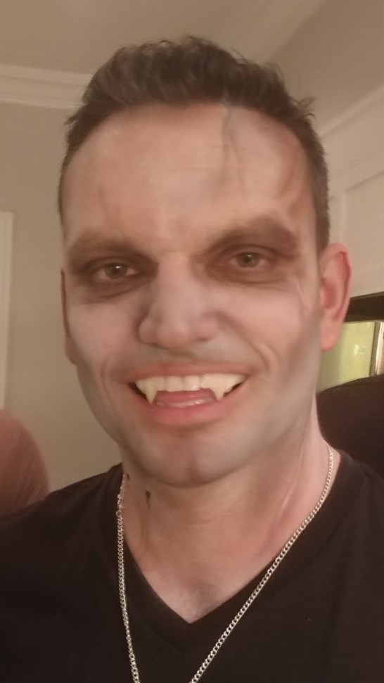 A man with makeup on his face and teeth.