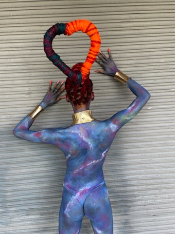 A woman with body paint on her back and arms.